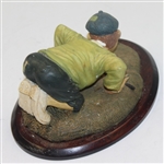 'History of Golf' Figure with Golfer Trying to Blow Ball in Hole